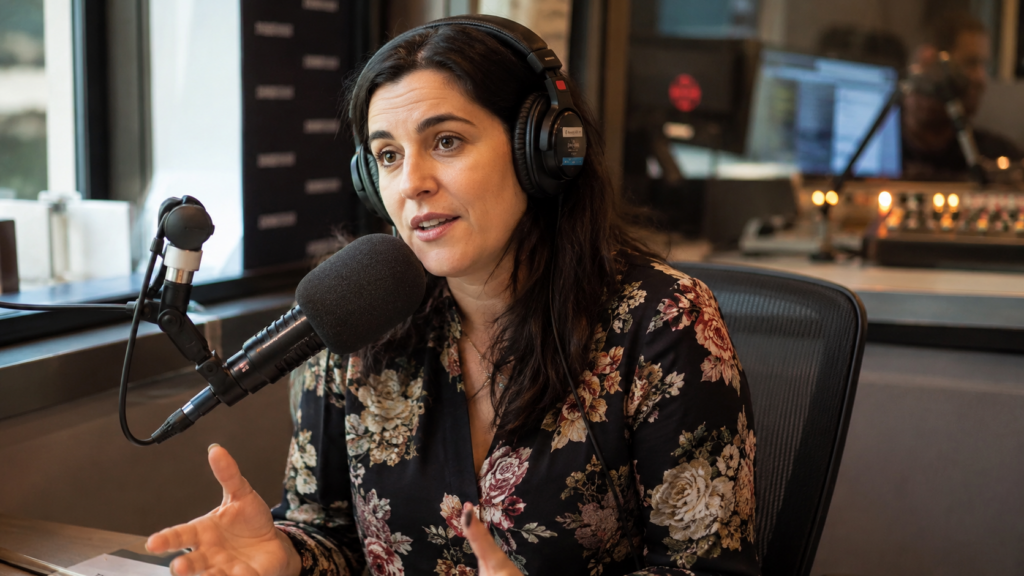 giornalista con cuffie parla al microfono in uno studio radiofonico professionale