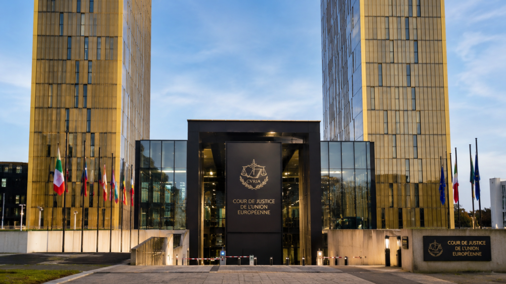 Facciata della Corte di giustizia dell’Unione europea a Lussemburgo, con le torri dalle vetrate dorate, l’ingresso istituzionale e le bandiere degli Stati membri