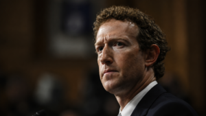 Mark Zuckerberg durante un’audizione, ritratto in primo piano con espressione seria.