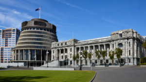 Parlamento della Nuova Zelanda a Wellington, con il caratteristico edificio Beehive affiancato dalla sede storica del Parlamento sotto un cielo azzurro.