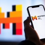 Smartphone con logo Mistral AI sullo schermo, tenuto in mano in primo piano, con il simbolo dell'azienda francese di intelligenza artificiale sfocato sullo sfondo.